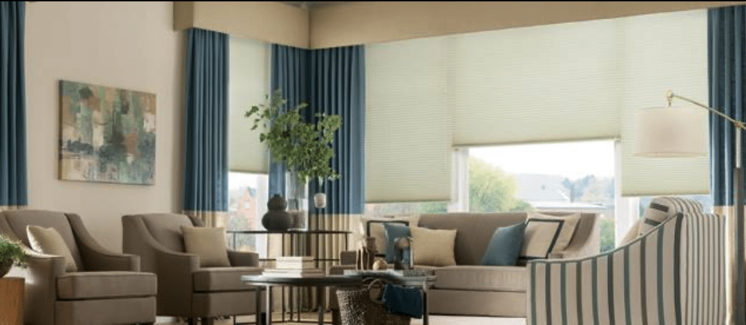 Layered drapery panels, roller shade, and cornice in living room